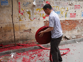 man with large roll of red firecrackers