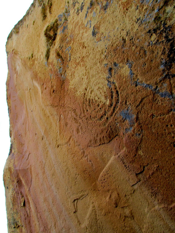 Boulder covered in weathered petroglyphs