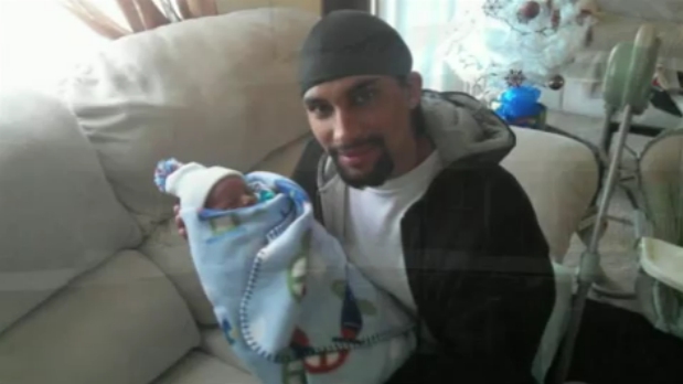 Ivan Evans poses with the child his accused of nearly burning to death.