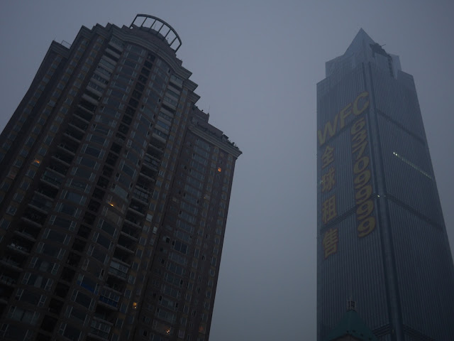 two tall buildings in hazy air and a grey sky in Chongqing