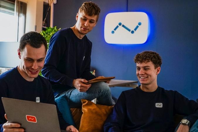 A group of men sitting on a couch looking at a computer

Description automatically generated with medium confidence