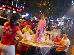 little girl standing on an outdoor restaurant table in Hengyang