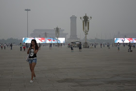 young woman walking and checking her phone at Tiananmen Square