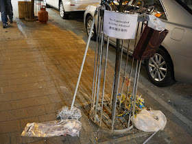 mop next to sign reading 'no unattended articles allowed' in Hong Kong