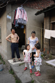 family of four standing outside their home
