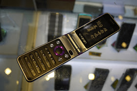 open flip phone in China with fake diamonds in the keypad, a QQ button, and an altered Oppo logo