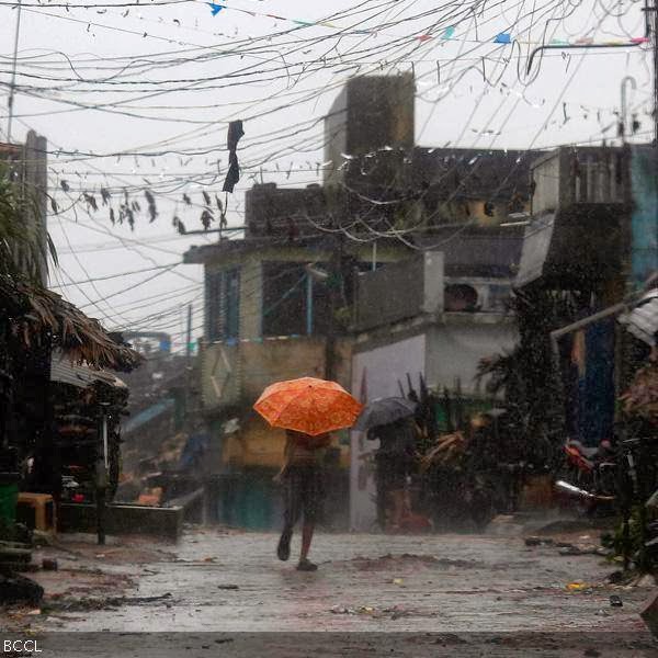 A man tries to cover himself with an umbrella during heavy rain brought by Cyclone Phailin as he moves towards a safer place at the village Donkuru in Srikakulam district in the southern Indian state of Andhra Pradesh.