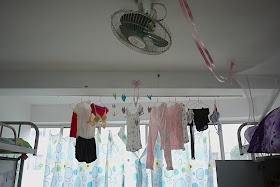 fan and hanging clothes inside a female dormitory room at Central South University of Forestry and Technology in Changsha, China.