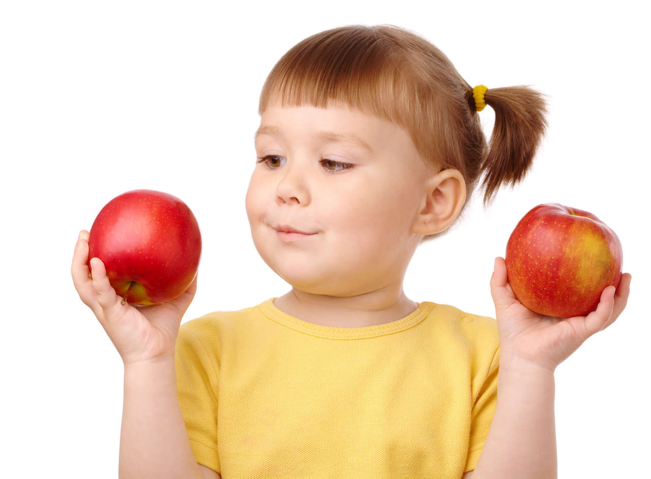 A kid holding two apples and choosing between them, similarly to the way that algorithms use conditionals to choose.