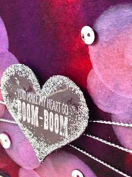 Linda Vich Creates: Valentine Round Up. A sequin-studded, jewel-toned watercolor bokeh background is embellished with a valentine heart strung on silver cords.