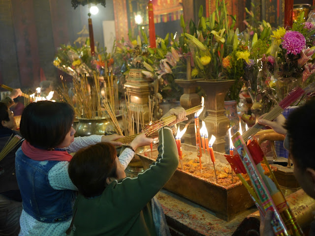 people lighting incense sticks in Kwun Yum Temple
