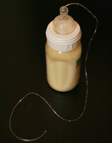 Homemade at-chest supplementer consisting of a bottle, nipple and tube.