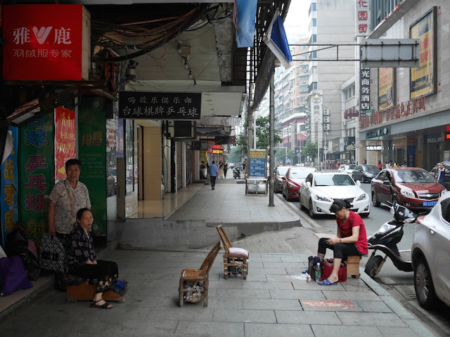 shoeshiners waiting for customers at the same location in Hengyang