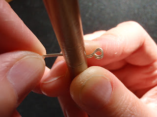 Bend the wire over a round pencil