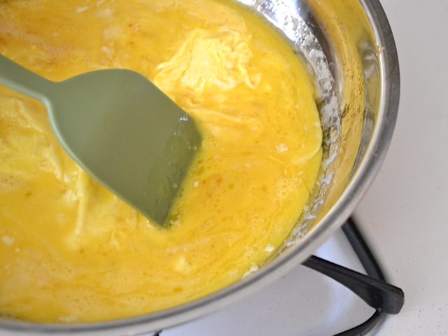 cooking eggs in skillet, stirring with spatula 
