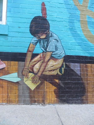 Native American boy making paper airplanes.