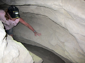Mary winds her way through one of the tighter mud caves