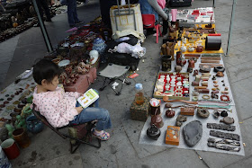 young girl reading an educational book outside Tianxinge Antique City in Changsha, China