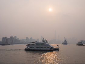 ferry crossing the Huangpu River on a smoggy day in Shanghai.