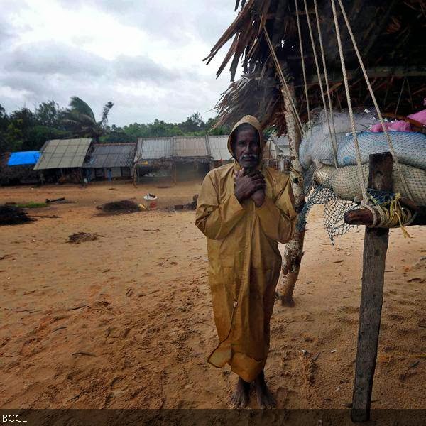 A man waits to be evacuated to a safer place as he stands near his fishing nets along the shore at the village of Donkuru in Srikakulam district, in the southern Indian state of Andhra Pradesh.
