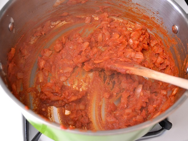 tomato paste added to onions and garlic in pot 