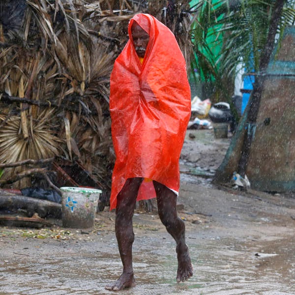 A man covers himself with a plastic sheet during heavy rain brought by Cyclone Phailin as he moves towards a safer place at the village Donkuru in Srikakulam district in the southern Indian state of Andhra Pradesh. 