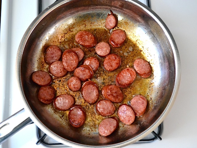 sausage cut into small pieces and cooking in skillet 
