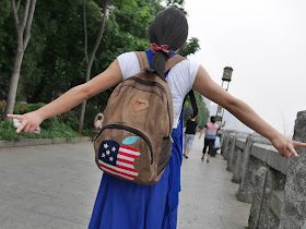 the young woman's backpack with a US flag colored Apple logo