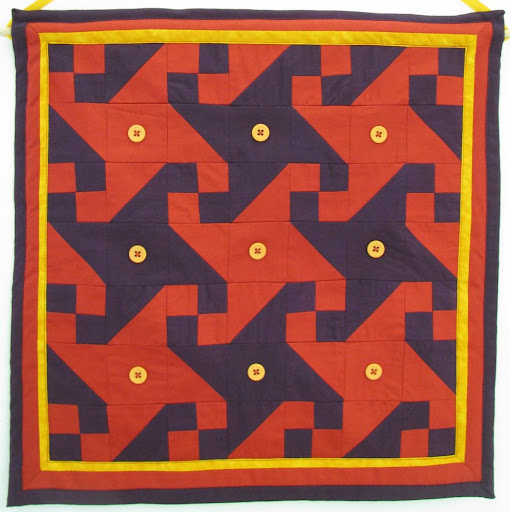 purple and orange quilt with yellow buttons