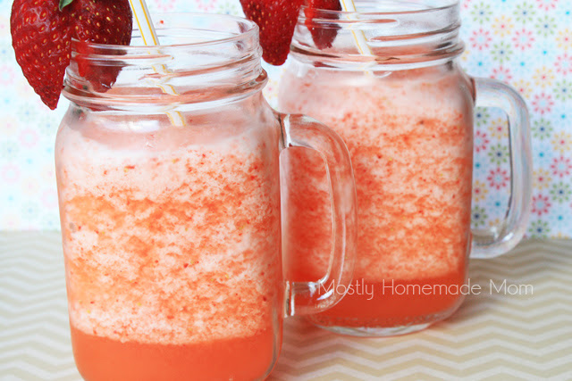 Two jar glasses of strawberry lemonade slushies.