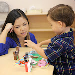 Moms watch as toddlers lead their own learning inspired by a variety of materials on the classroom shelves such as this chunky farm animal puzzle.