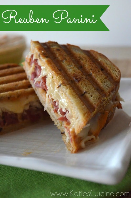 Sliced Reuben sandwiches pressed with lines on a white plate. 