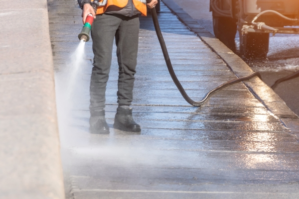 cleaning-driveway-with-high-pressure-washer-splashing-dirt