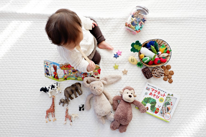 kid playing with toys on white mat