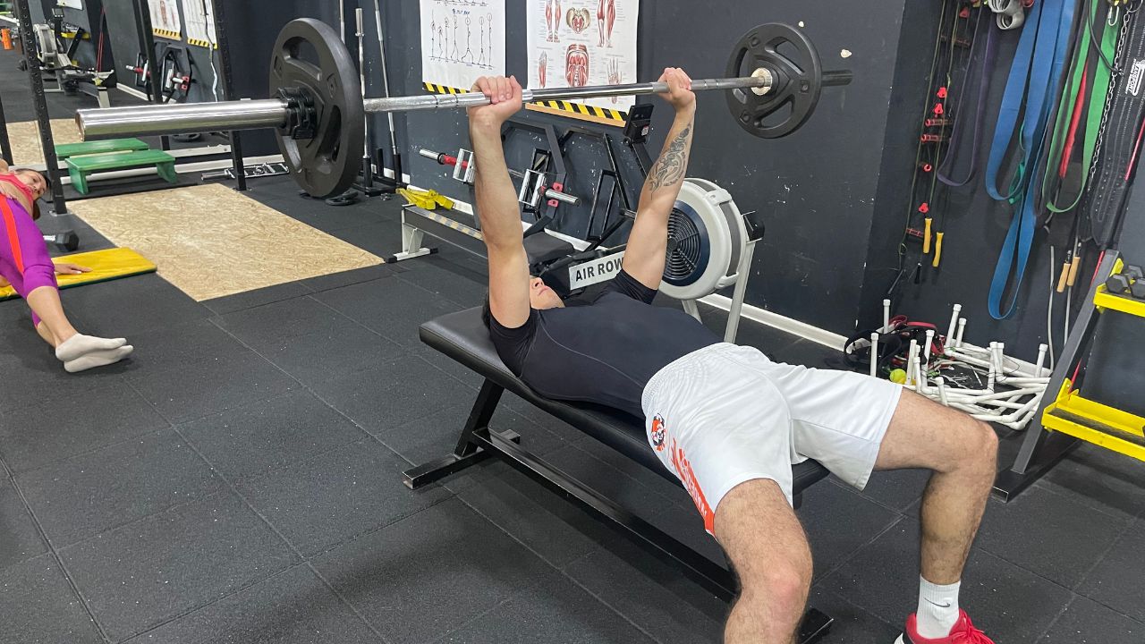 Vanja performs a barbell bench press.