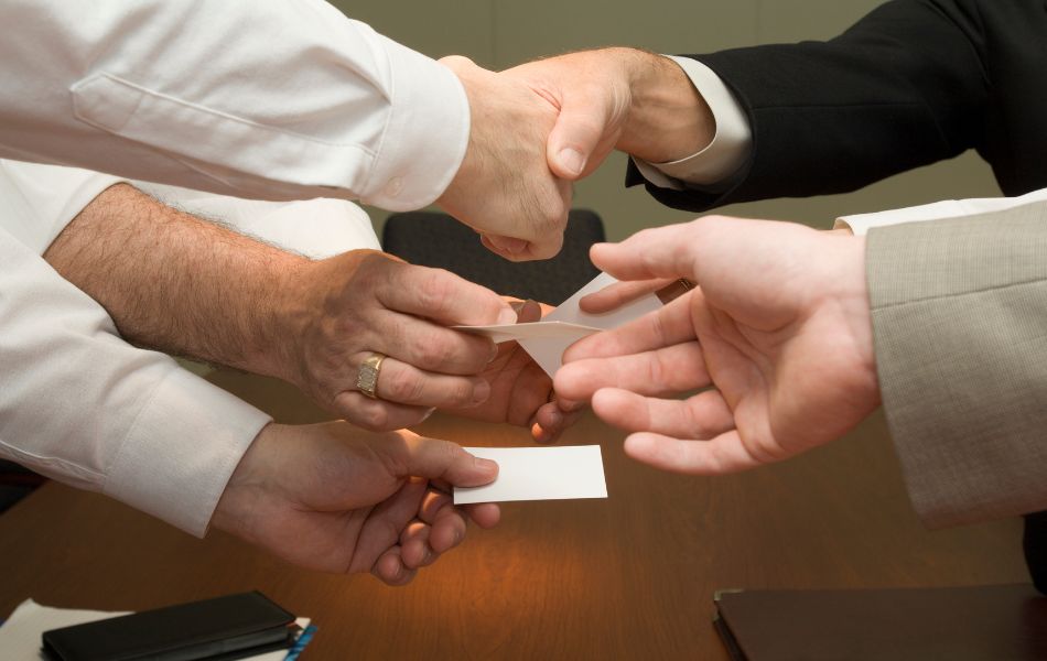 Six different hands exchanging cards.