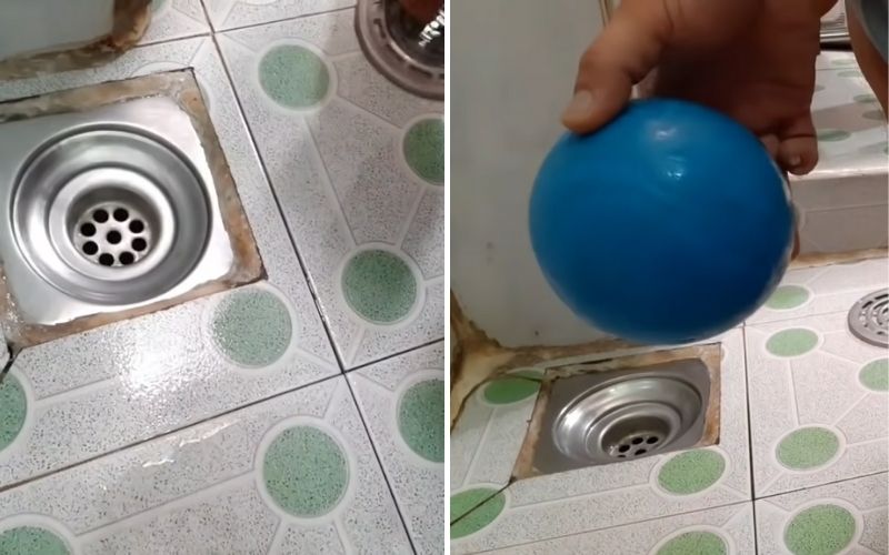 Bạn gỡ nắp đậy cống thoát nước ra và dùng một quả banh nhựa đặt vào miệng cống