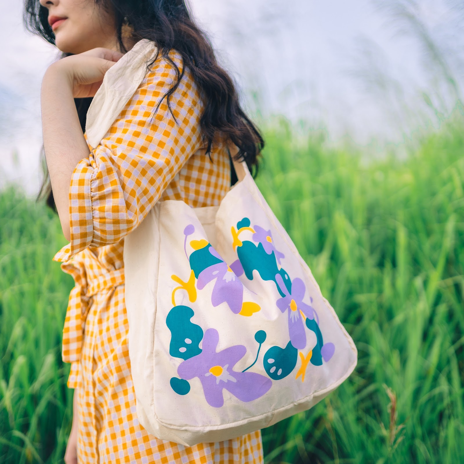 花柄のキャンバス地バッグを持つ女性