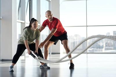 Fitness Instructor with client doing rope exercises