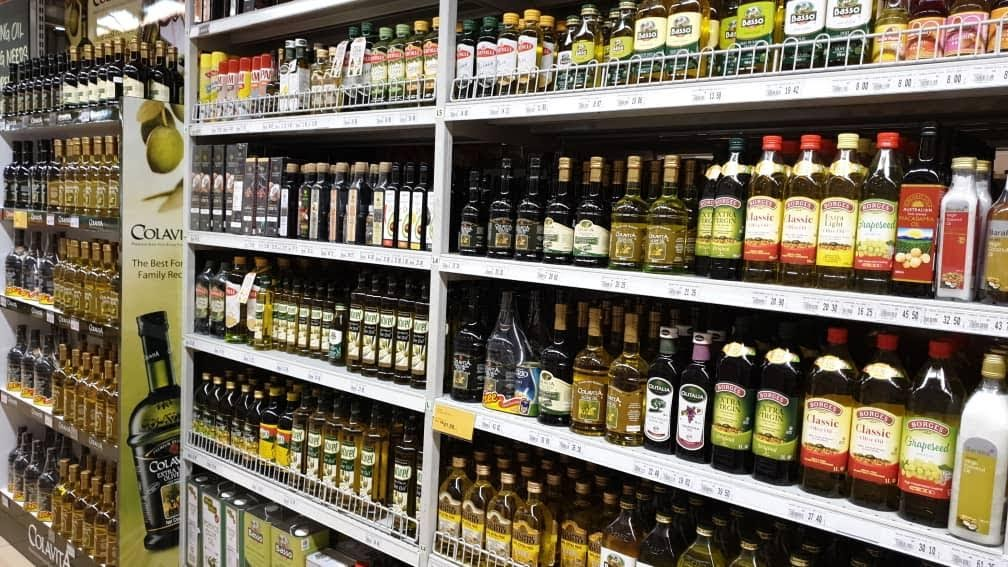 Lineal de aceites de oliva en supermercado. Banco de imágenes ESAO