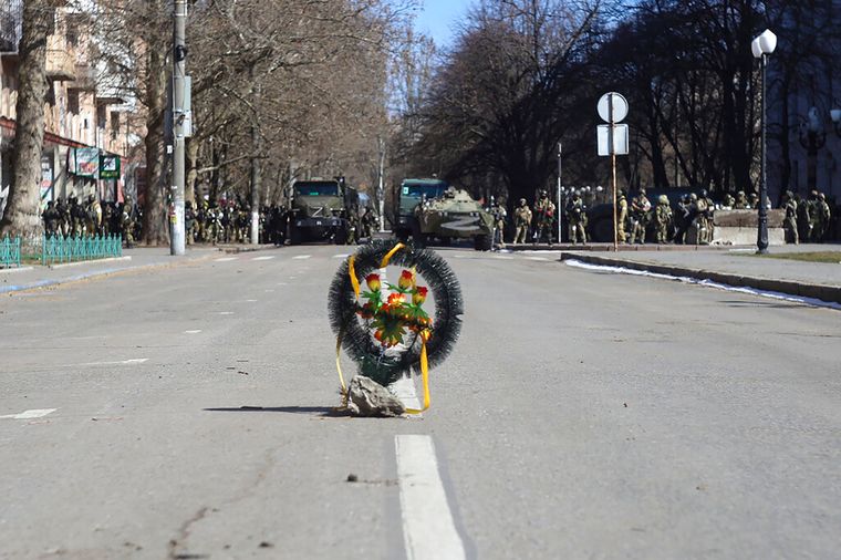 Погребальный венок, возложенный на улице напротив кордона российских солдат, во время митинга против российской оккупации в Херсоне, 13 марта 2022 года