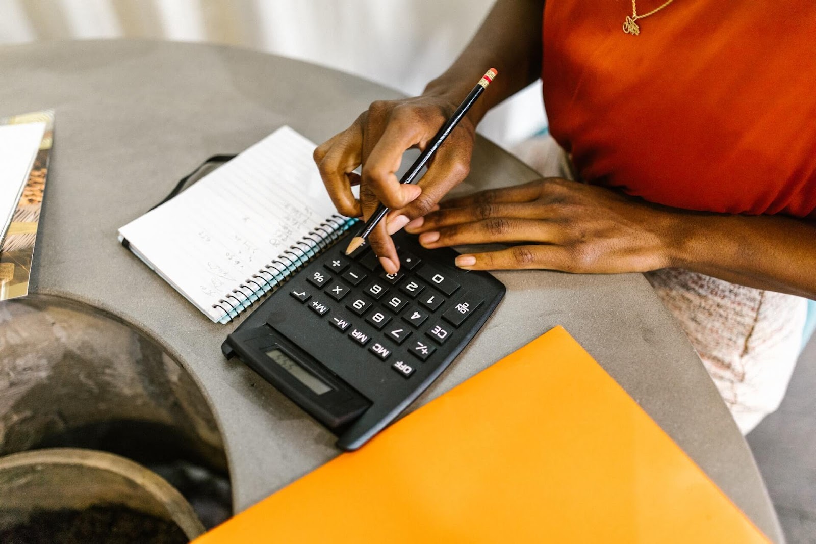 Woman typing on a calculator on her desk