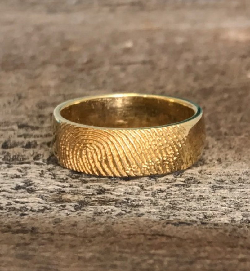 A gold ring on a marbled surface

Description automatically generated with medium confidence