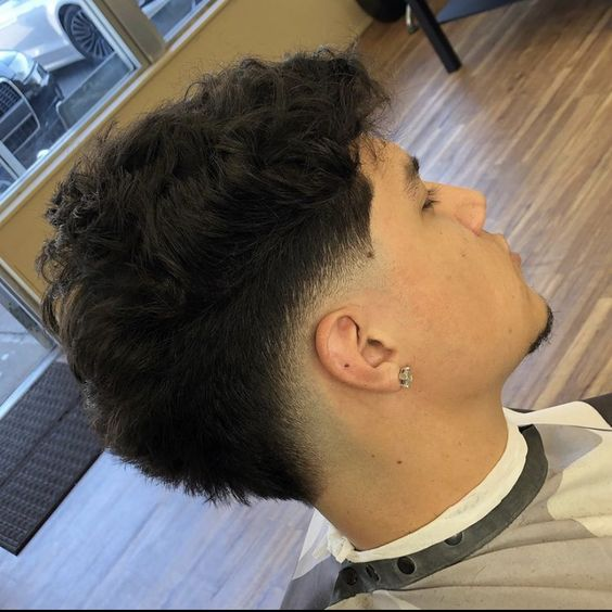 Guy in a barber shop shows off his stylish hairstyle