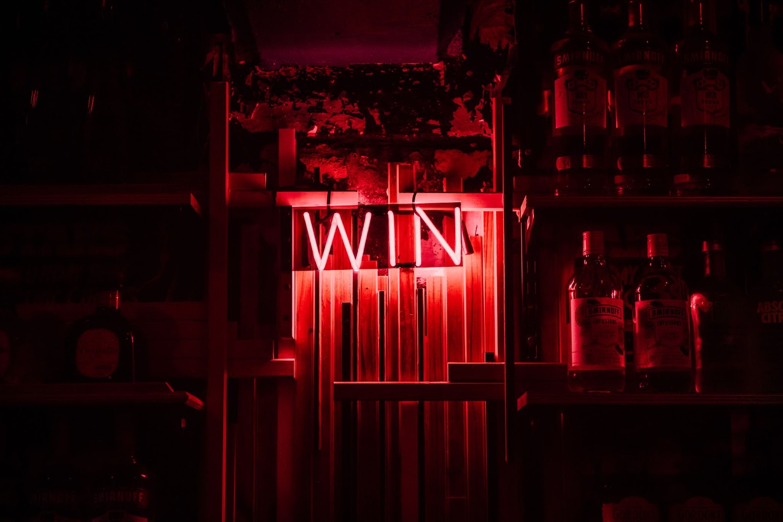 A dimly lit bar with a bright red neon sign that says WIN 