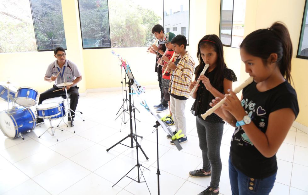 El profesor Espinoza dirige a los participantes de la escuela de música.