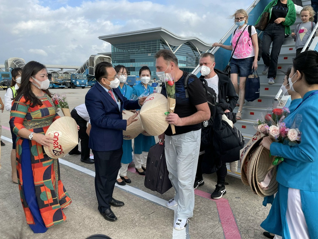 State officials directly welcome and give flowers to the first visitors to Vietnam after reopening the border