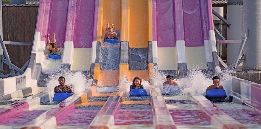 Kids sliding down a water slide at Six Flags Hurricane Harbor in Arlington, TX.