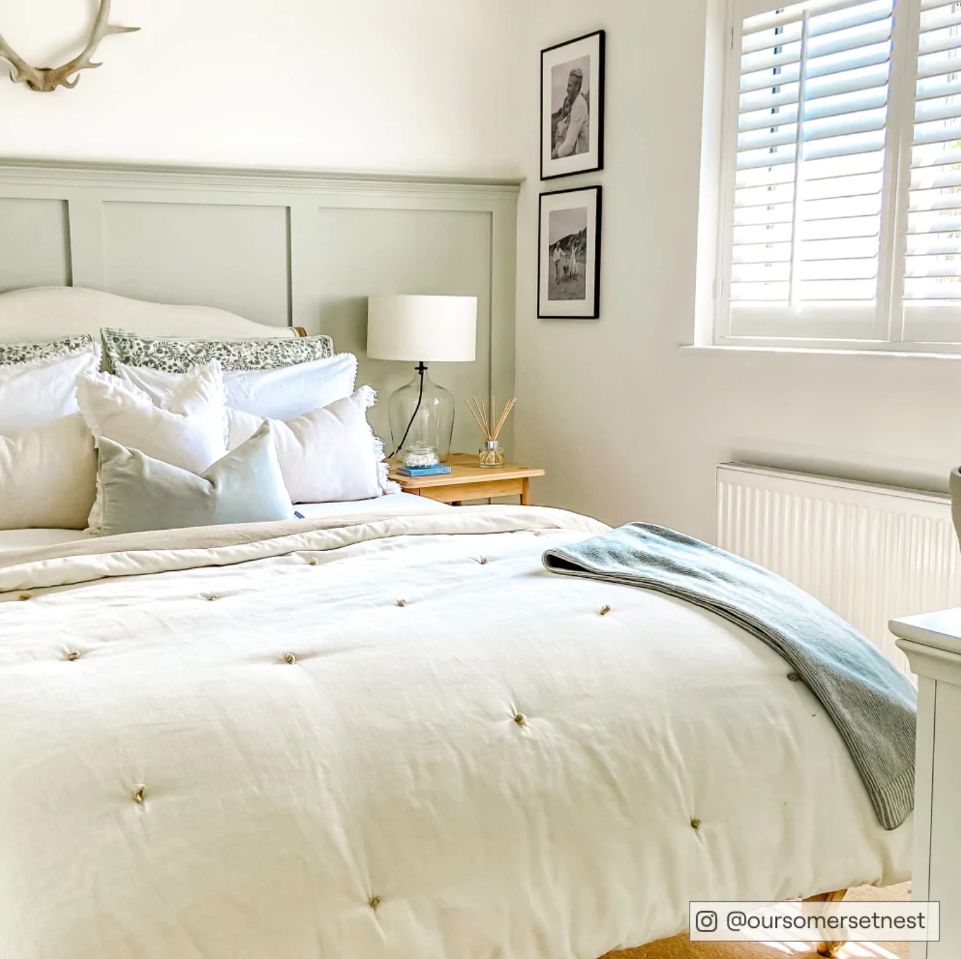 Calming master bedroom with panelling painted in sage green