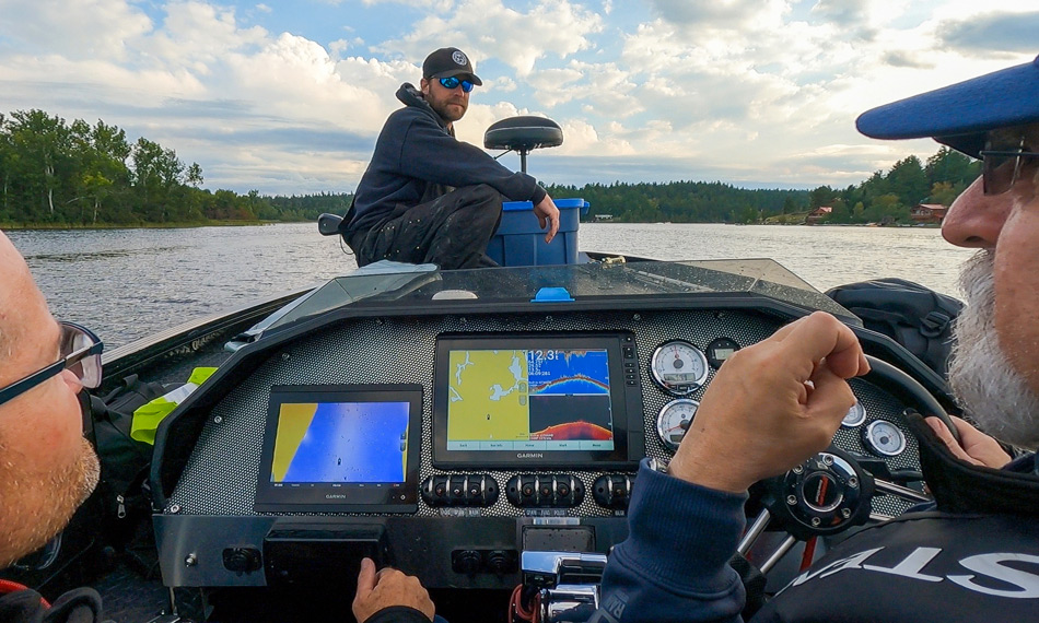 Three anglers looking at a Garmin fishfinder while on the way to Garden Island Lodge